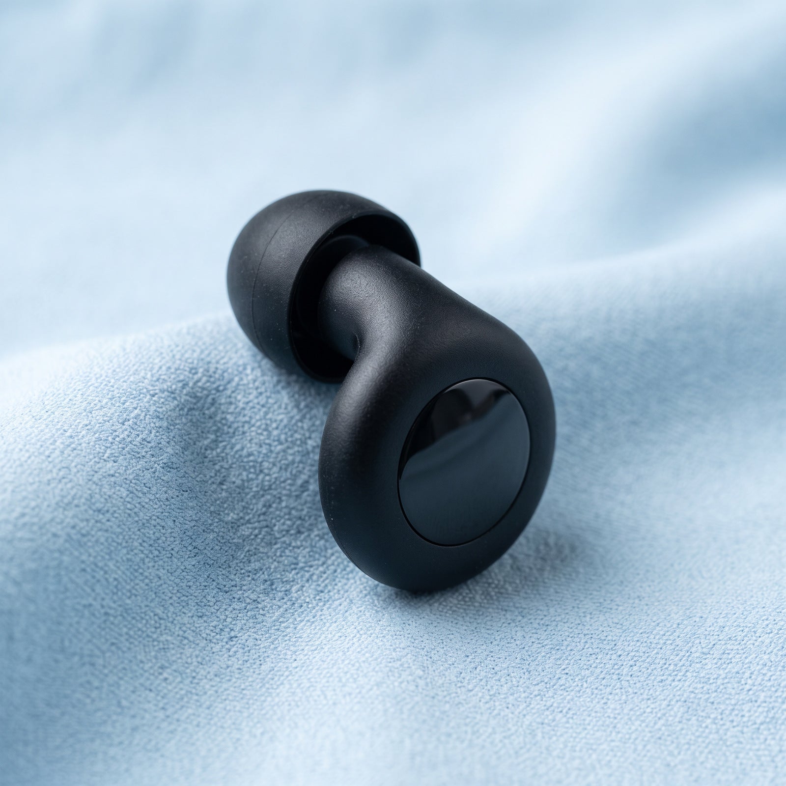 Black Stillday earplug and soft tip on blue cloth