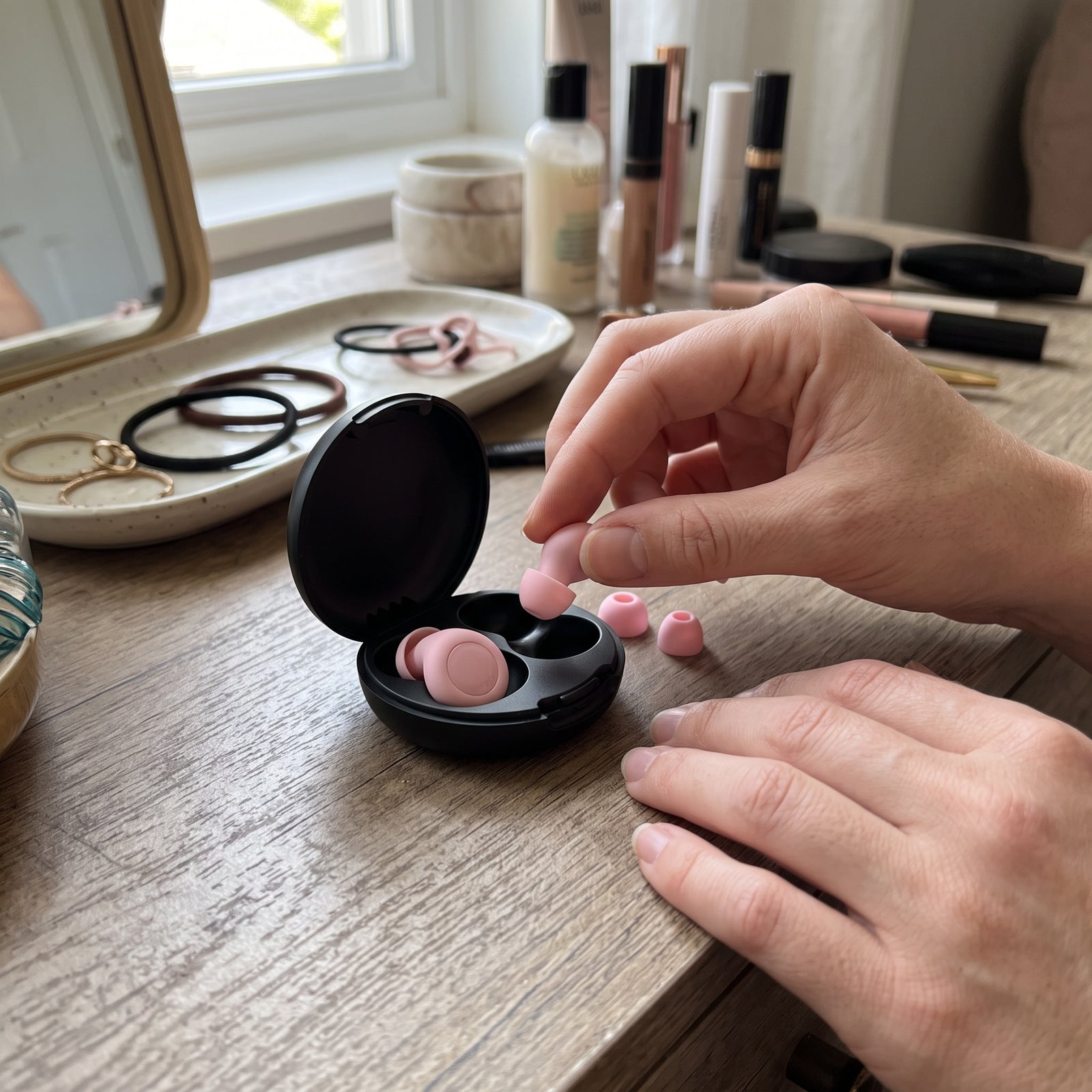 Hands choosing a Pink silicone tip beside an open black case