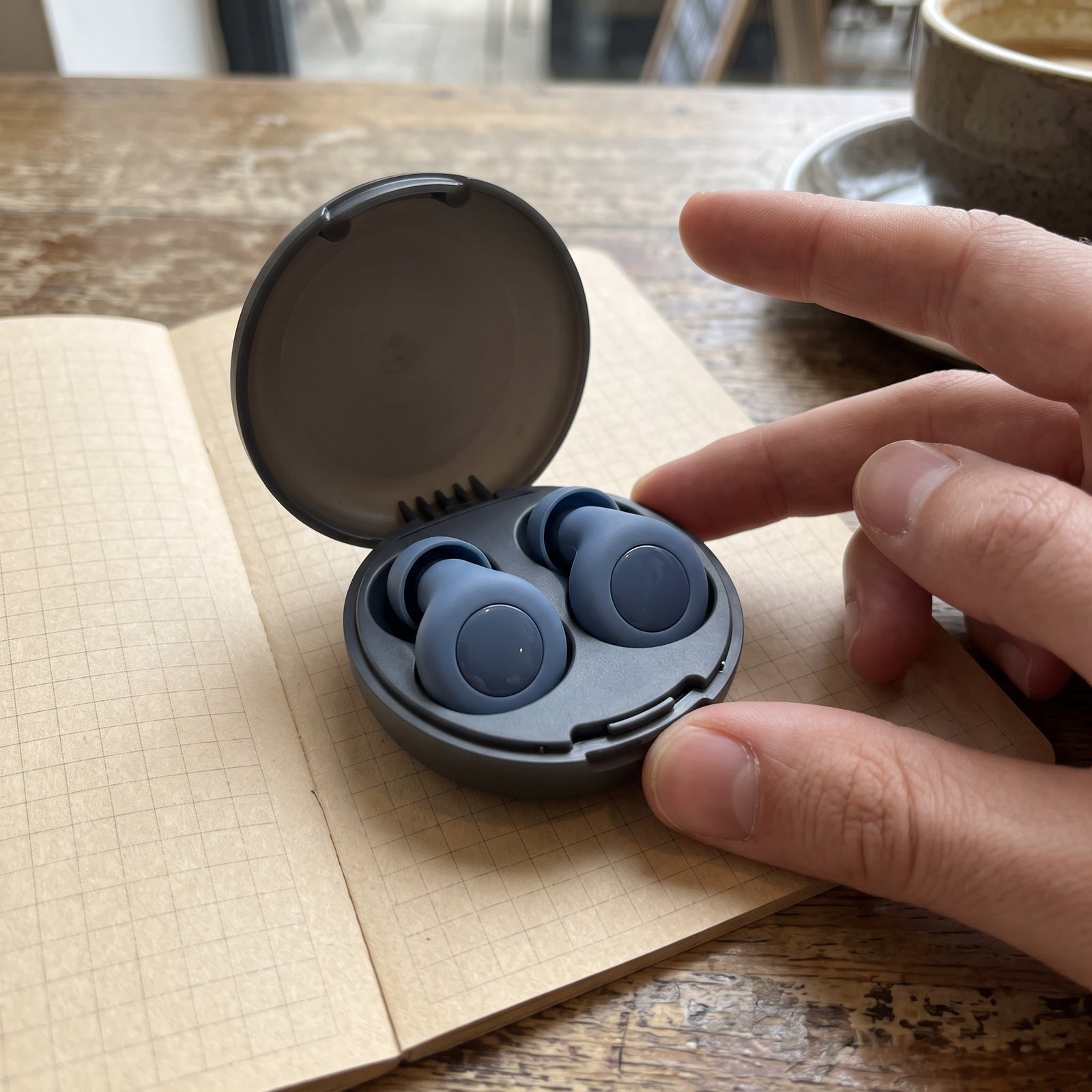 Blue Stillday pair in an open case on a cafe notebook